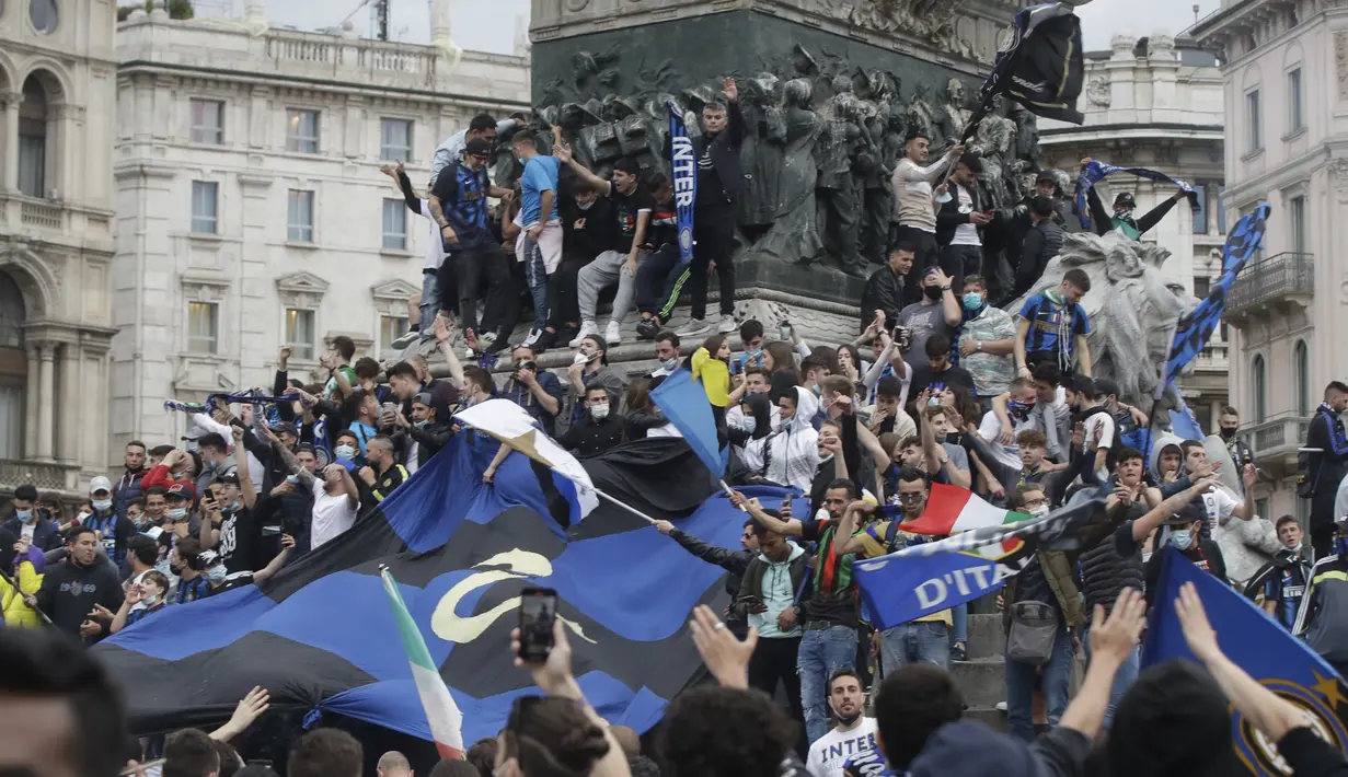 Suporter Inter Milan merayakan dan berteriak di alun-alun Piazza Duomo di depan katedral gotik setelah Inter Milan memenangkan gelar Serie A pertamanya dalam lebih dari satu dekade setelah tim urutan kedua Atalanta bermain imbang 1-1 di Sassuolo, di Milan, Italia (2/5/2021). (AP Photo/Luca Bruno)