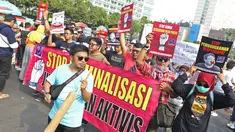 Jurnalis yang tergabung dalam Aliansi Jurnalis Independen (AJI) menggelar aksi jalan mundur saat Car Free Day di Bundaran HI, Jakarta, Minggu (29/9/2019). Kegiatan tersebut bentuk desakan agar Polda Metro Jaya mencabut status tersangka jurnalis Dandhy Dwi Laksono. (Liputan6.com/Herman Zakharia)