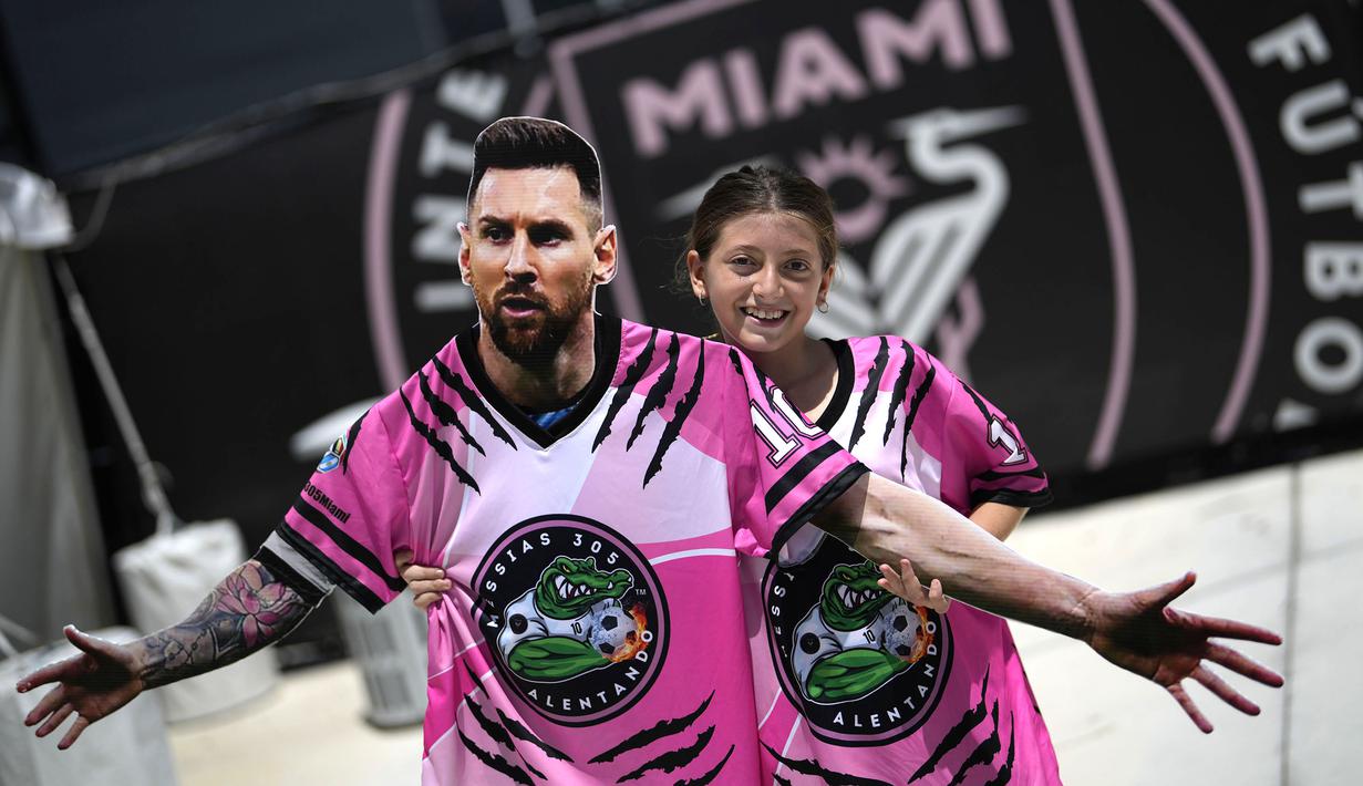 <p>Seorang gadis membawa potongan karton berbentuk pemain baru Inter Miami, Lione Messi saat menunggu di luar Stadion DRV Pink, Miami, 11 Juli 2023. Transfer Messi menjadi paling menggemparkan pada musim panas 2023/2024. La Pulga memilih hengkang dari PSG menuju Inter Miami. Klub milik legenda sepak bola Inggris, David Beckham tersebut diketahui rela merogoh kocek 35 juta euro untuk mendatangkan sang bintang Argentina tersebut. (AP Photo/Rebecca Blackwell)</p>