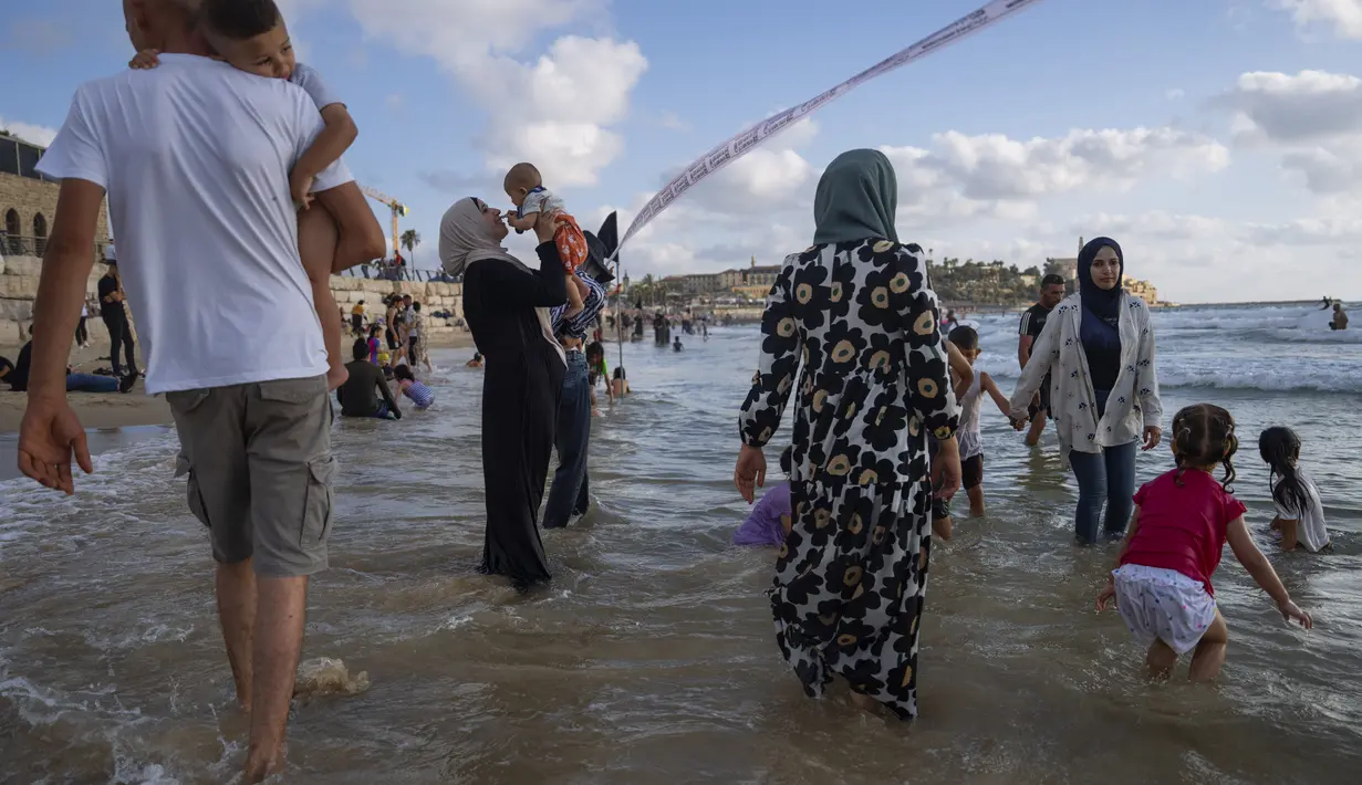 Wisata pantai di pesisir laut Mediterania ini menjadi tujuan alternatif warga Palestina untuk menghabiskan hari libur Idul Adha. (AP Photo/Oded Balilty)