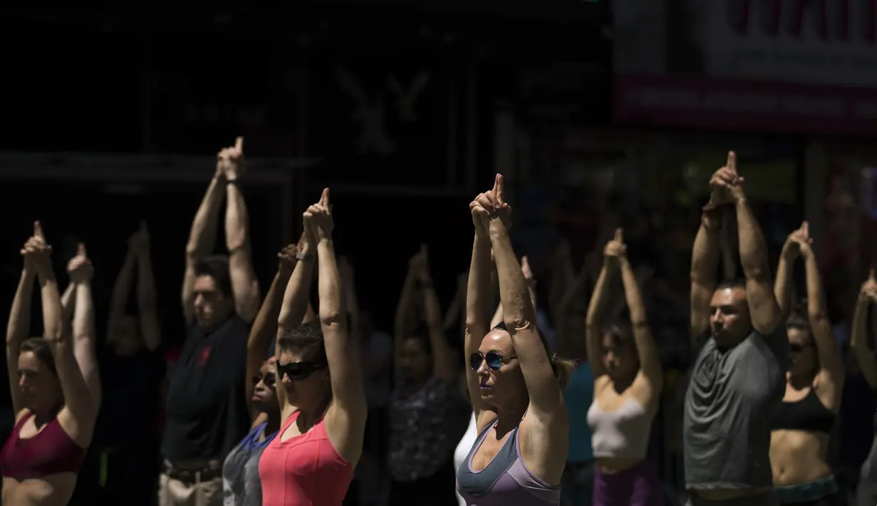 Peserta berpartisipasi dalam yoga outdoor di kawasan Times Square, New York saat Summer Solstice atau hari dengan siang terpanjang di musim panas, Kamis (21/6). Acara itu menandai Hari Yoga Internasional yang jatuh pada 21 Juni (TIMOTHY A. CLARY/AFP)