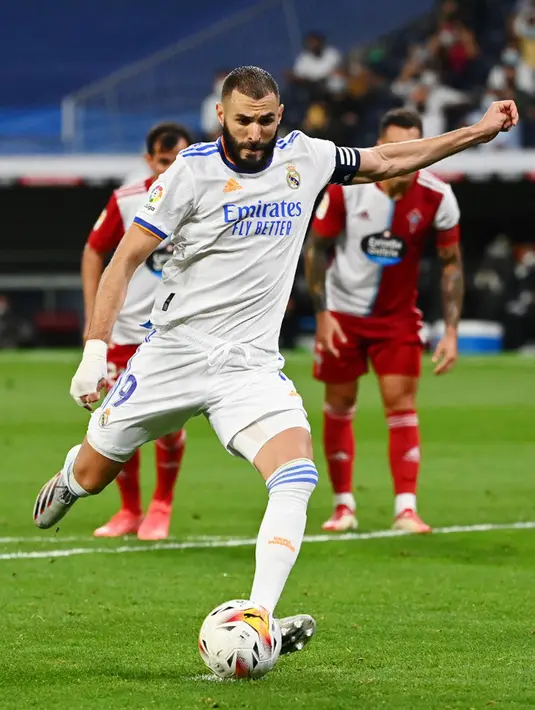 Pemain Real Madrid Karim Benzema melakukan tendangan penalti dan mencetak gol ke gawang Celta Vigo pada pertandingan Liga Spanyol di Stadion Santiago Bernabeu, Madrid, Spanyol, 12 September 2021. Karim Benzema mencetak hattrick saat Real Madrid mengalahkan Celta Vigo 5-2. (GABRIEL BOUYS/AFP)