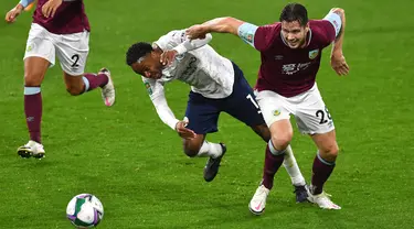 Penyerang Manchester City, Raheem Sterling berebut bola dengan pemain  Burnley, Kevin Long pada laga babak keempat Piala Liga Inggris di Turf Moor, Kamis (1/10/2020) dini hari WIB. Raheem Sterling mencetak dua gol saat Manchester City menang 3-0 atas Burnley. (Paul Ellis/Pool via AP)