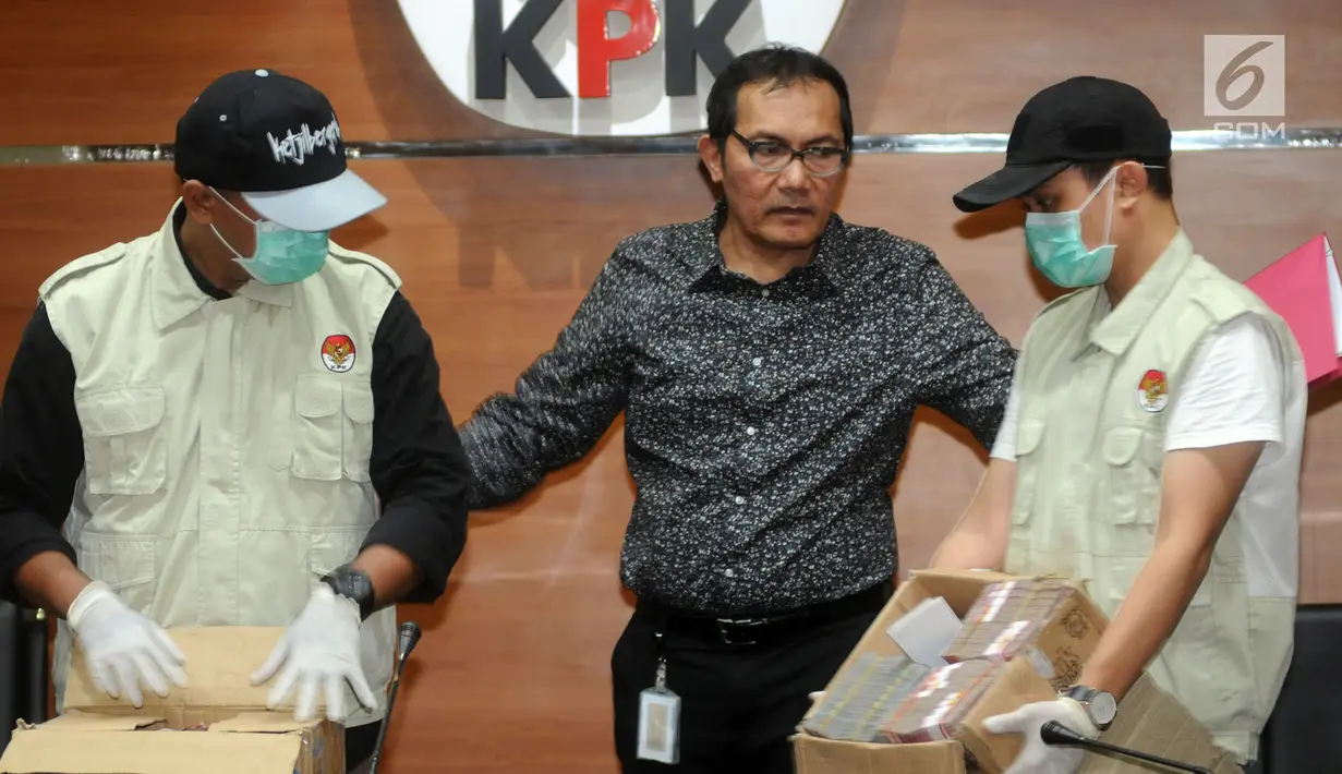 Wakil Ketua KPK Saut Situmorang bersama petugas bersiap menunjukkan barang bukti uang 2,5 Miliar hasil OTT di dua wilayah Kota Blitar dan Kabupaten Tulungagung, Jakarta, Jumat (9/6). (Merdeka.com/Dwi Narwoko)
