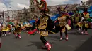 Sejumlah penari mengenakan kostum dan topeng saat parade tahunan untuk menghormati "El Senor del Gran Poder" atau "The Lord of Great Power" di La Paz, Bolivia (10/6). Parade ini juga bentuk terima kasih mereka kepada dewa. (AP Photo / Juan Karita)