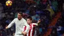 Penyerang Real Madrid, Cristiano Ronaldo, duel udara dengan pemain Sporting Gijon, Jorge Mere. Pada laga ini kedua gol Los Blancos dicetak oleh CR 7. (Reuters/Susana Vera)