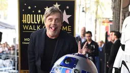 Pemeran Luke Skywalker dalam film "Star Wars", Mark Hamill berpose dengan karakter droid R2-D2 saat upacara pemberian Hollywood Walk of Fame di Los Angeles (8/3). (Jordan Strauss / Invision / AP)