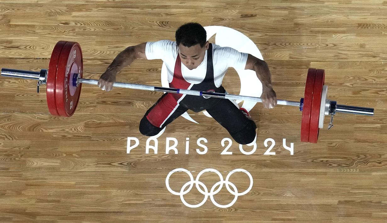 Lifter Indonesia, Eko Yuli Irawan berusaha melakukan angkatan pada cabor angkat besi Olimpiade Paris 2024 di South Paris Arena, Paris, Prancis, Rabu (07/08/2024). (AP Photo/Pool/Dita Alangkara)