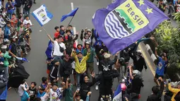 Para pendukung Persib Bandung yang dikenal dengan sebutan bobotoh melakukan pawai di Kota Bandung, Sabtu (1/6/2024) untuk menyambut kedatangan skuad Persib Bandung usai menjadi juara Championship Series BRI Liga 1 2023/2024. (Bola.com/M Iqbal Ichsan)