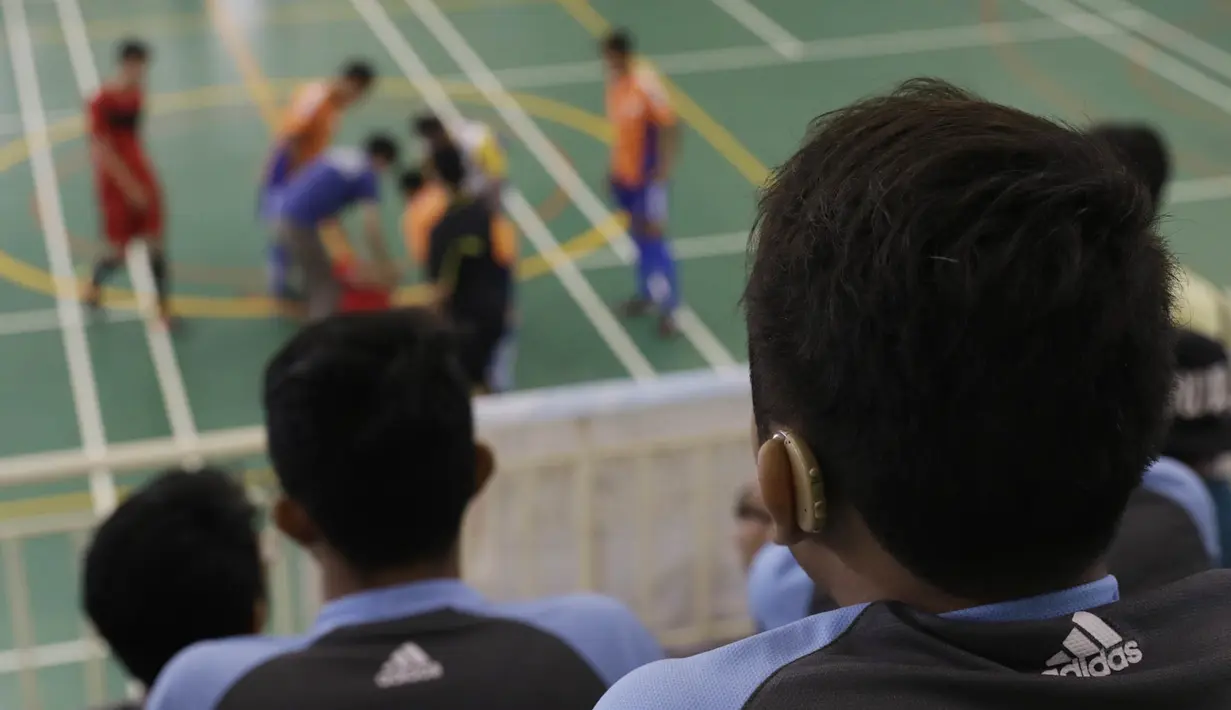 Seorang pesepak bola menggunakan alat bantu pendengaran saat akan bertanding pada Kejuaraan Futsal Tuna Rungu di GOR Ciracas, Jakarta, Sabtu (7/11/2015). (Bola.com/Vitalis Yogi Trisna)