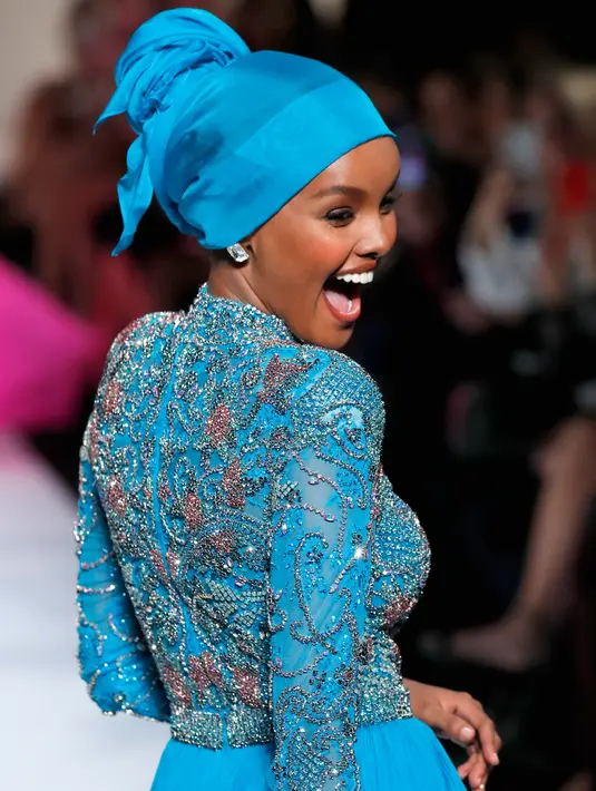Model Halima Aden berjalan di atas catwalk menggenakan busana rancangan Sherri Hill Show selama New York Fashion Week 2019 di New York City (8/2). Model 21 tahun ini merupakan model pertama yang menggunakan hijab. (AFP Photo/Ben Gabbe)