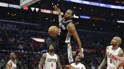 Ekspresi pemain San Antonio Spurs, Kawhi Leonard (tengah) saat memasukan bola melewati hadangan para pemain L. A. Clippers pada laga NBA basketball game di Staples Center, (22/12/2016). Clippers menang 106-101. (AP/Jae C. Hong)