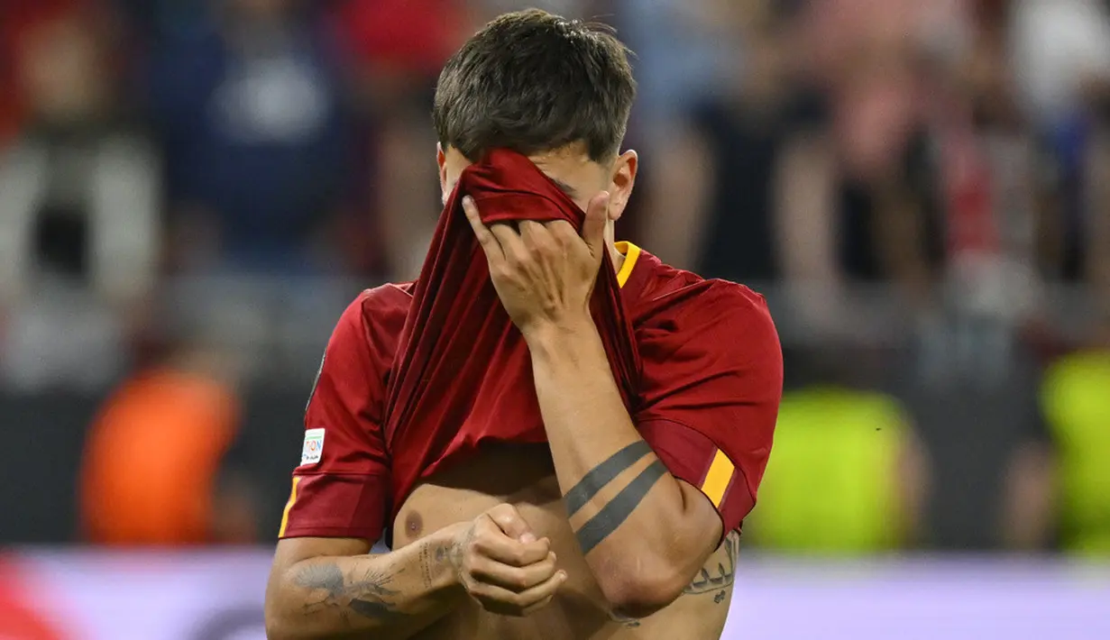 <p>Paulo Dybala berkali-kali tertangkap kamera menutup wajahnya dengan jersey yang dia kenakan. Dia terlihat mengusap air matanya. (AP Photo/Denes Erdos)</p>