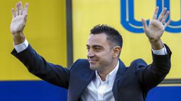 Xavi pun yang kini tampil berbeda dengan balutan jas parlente membalas sambutan para fans dengan lambaian tangan penuh kehangatan. (AP/Joan Monfort)