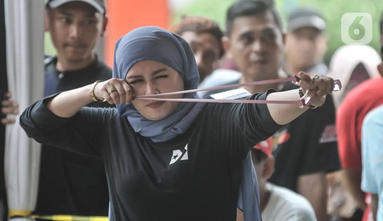 Selain pria, kaum perempuan juga turut meramaikan lomba katapel  saat Gebyar Budaya Nganten Temat II di RPTRA Dahlia, Kramat Jati, Jakarta Timur, Minggu (26/6/2022). Lomba katapel tersebut digelar oleh Komunitas Ketapel Condet (Kecot) bersama Wali Kota Jakarta Timur. (merdeka.com/Iqbal S Nugroho)