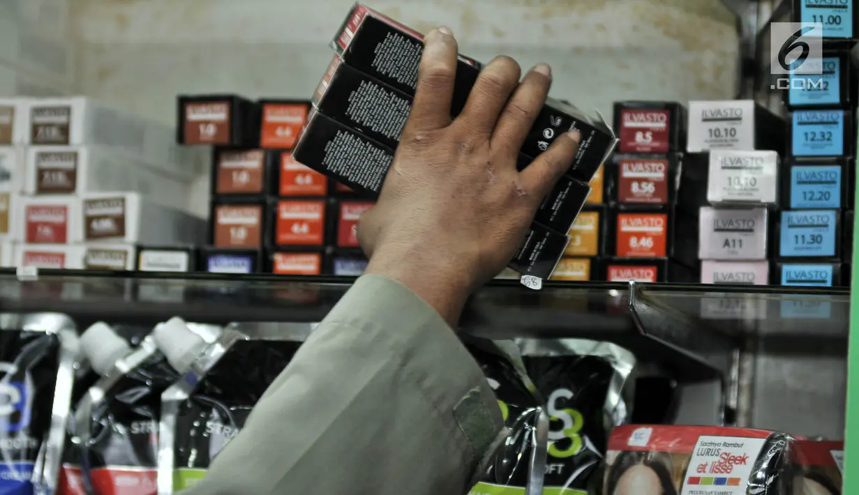 Petugas Satpol PP menyita sejumlah kosmetik saat melakukan razia di pertokoan Pasar Baru, Jakarta, Rabu (12/12). Razia tersebut guna mencegah peredaran produk kosmetik yang tidak dilengkapi surat izin dan kedaluwarsa. (Merdeka.com/Iqbal S. Nugroho)