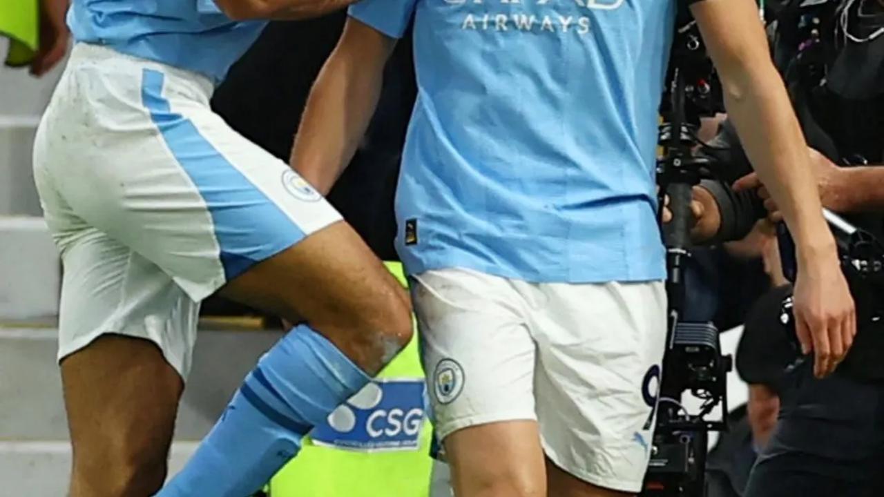 Erling Braut Haaland saat merayakan gol kedua bersama Rodri.