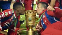 David Alaba (kiri) dan Franck Ribery mencium trofi saat perayaan kemenangan Bayern München atas Borussia Dortmund di final DFB Pokal yang digelar di Olympiastadion, Berlin (18/5/2014). (AFP PHOTO/Odd Andersen)
