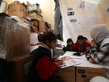 Seorang psikolog merawat anak-anak yang terdampak oleh gempa bumi berkekuatan 7,8 magnitudo yang melanda wilayah perbatasan Turki dan Suriah, Kahramanmaras, Senin (12/2/2023). Gempa dahsyat yang melanda Turki dan Suriah telah menelan puluhan ribu korban meninggal dunia. Korban tewas mencapai lebih dari 24.000 di Turki dan Suriah, saat ini upaya penyelamatan terus berlanjut. (OZAN KOSE/AFP)