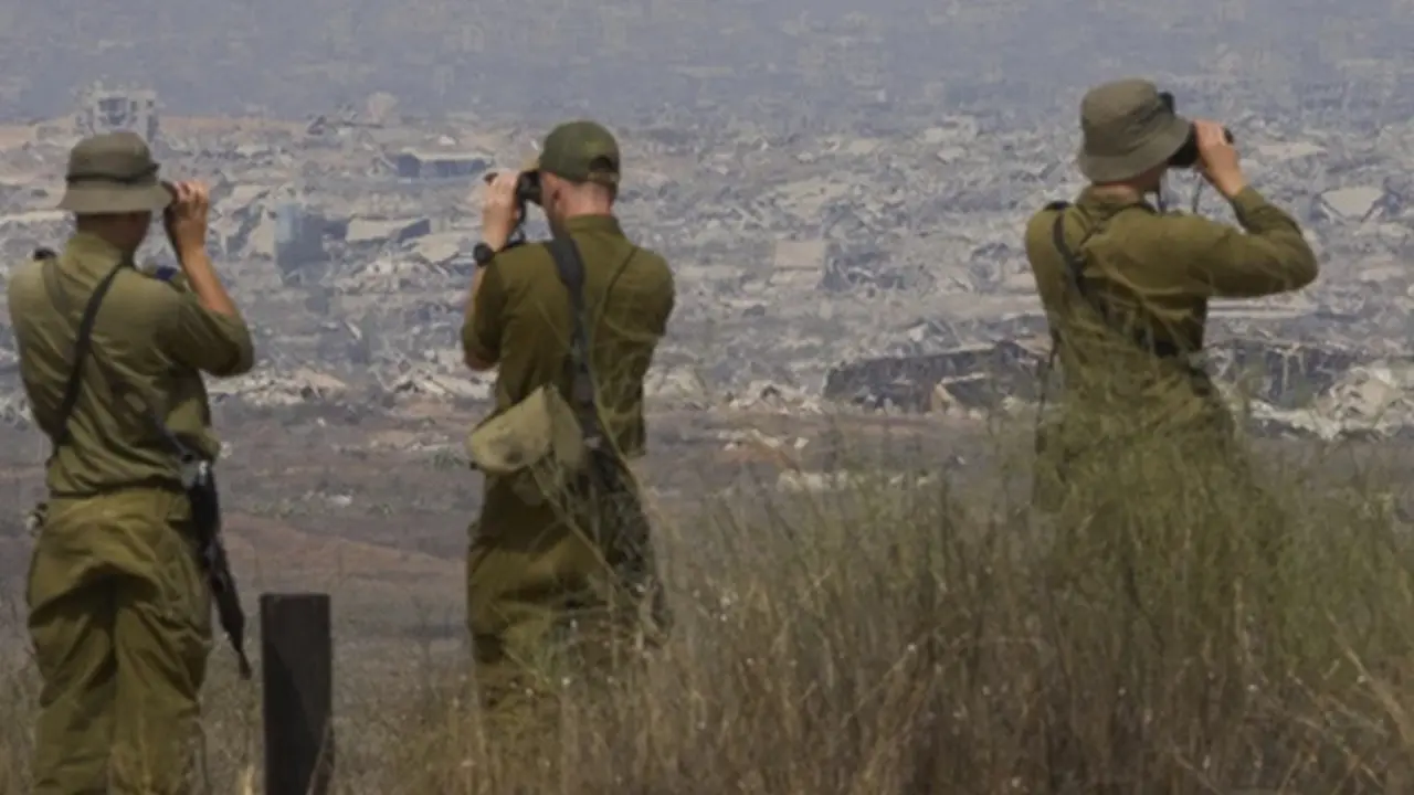 Prajurit Israel menggunakan teropong untuk melihat bangunan yang rusak di Gaza dari Israel selatan, Rabu (13/8/2025).