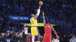 Pebasket Los Angeles Lakers, LeBron James melakukan lemparan three poin dibayangi pebasket New Orleans Pelicans, Zion Williamson untuk mencetak 50.002 poin dalam sejarah NBA di Crypto Arena, Los Angeles, Rabu (05/03/2025) pagi WIB. (AP Photo/Jae C. Hong)