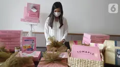 Pendiri Tomaple Gourmet Potato Donuts, Lala Ursula menyiapkan hampers untuk konsumen di salah satu outlet Tomaple di Jakarta, Sabtu (08/5/2021). Donat yang mampu berkreasi dengan pasar milenial dan didominasi warna pink mengusung tema #pinkboxhappines. (Liputan6.com/HO/Tomaple)