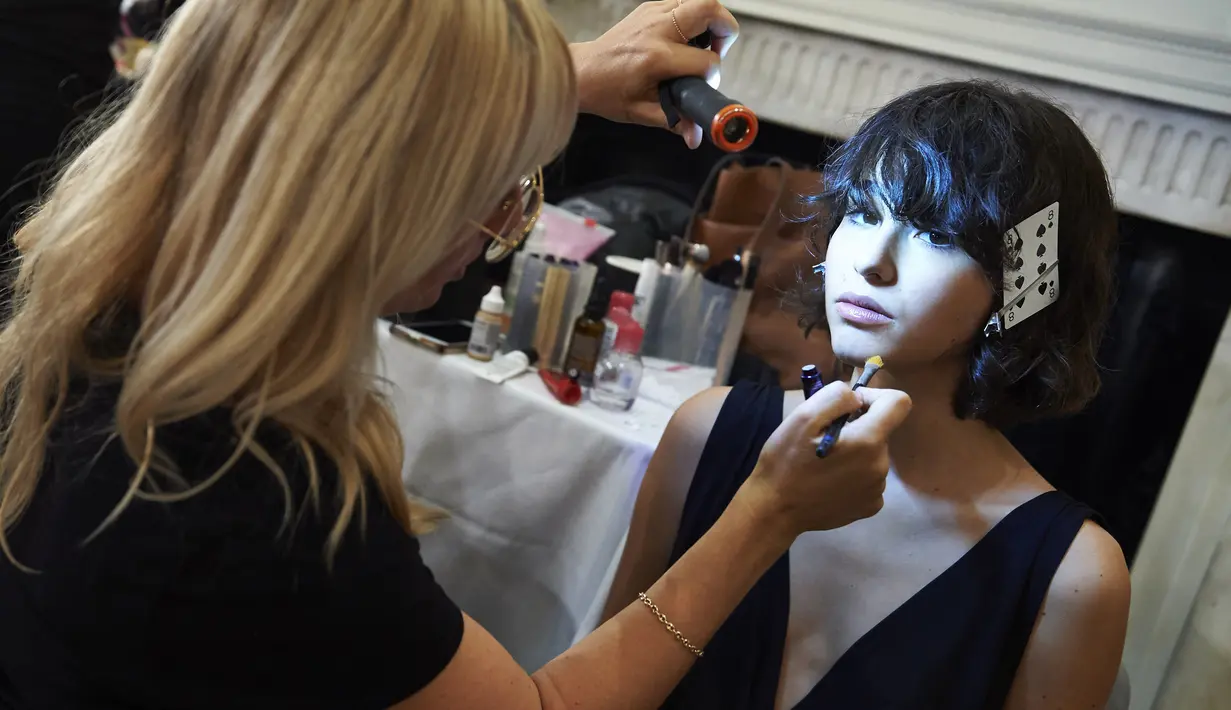 Model saat dirias di belakang panggung sebelum membawakan busana perancang Inggris Jasper Conran Spring / Summer 2018 pada hari kedua The London Fashion Week Women's di London, Inggris (16/9). (AFP Photo/Niklas Halle'n)