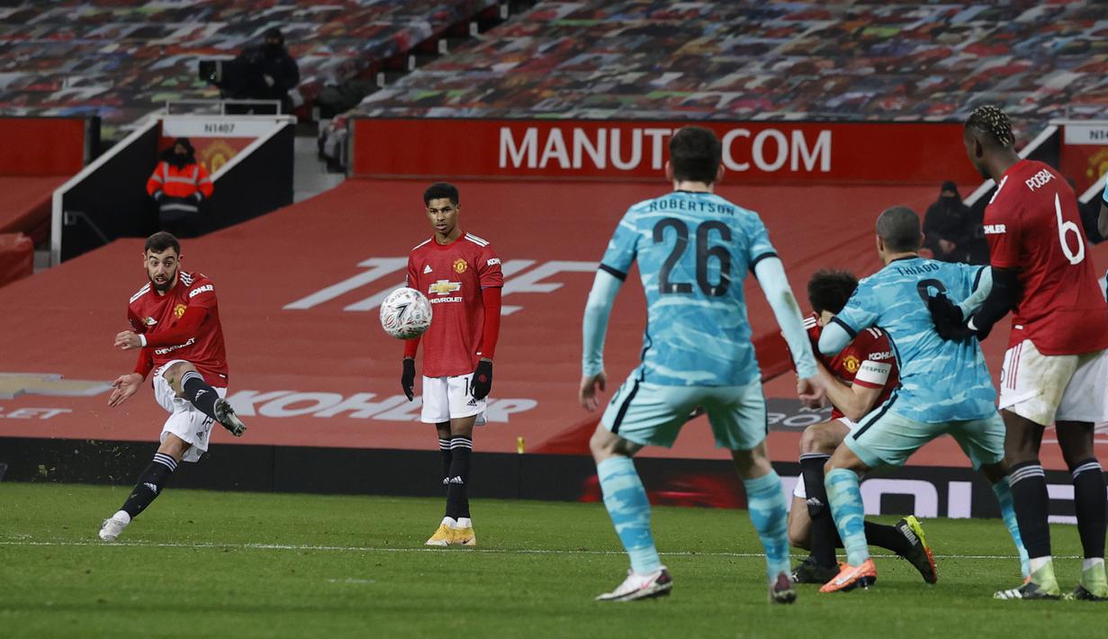 Tendangan bebas pemain Manchester United, Bruno Fernandes (kiri) berhasil menjebol gawang Liverpool pada laga babak keempat FA Cup 2020-21 di Old Trafford, Senin (25/01/2021). (Foto: AP/Pool/Phil Noble)