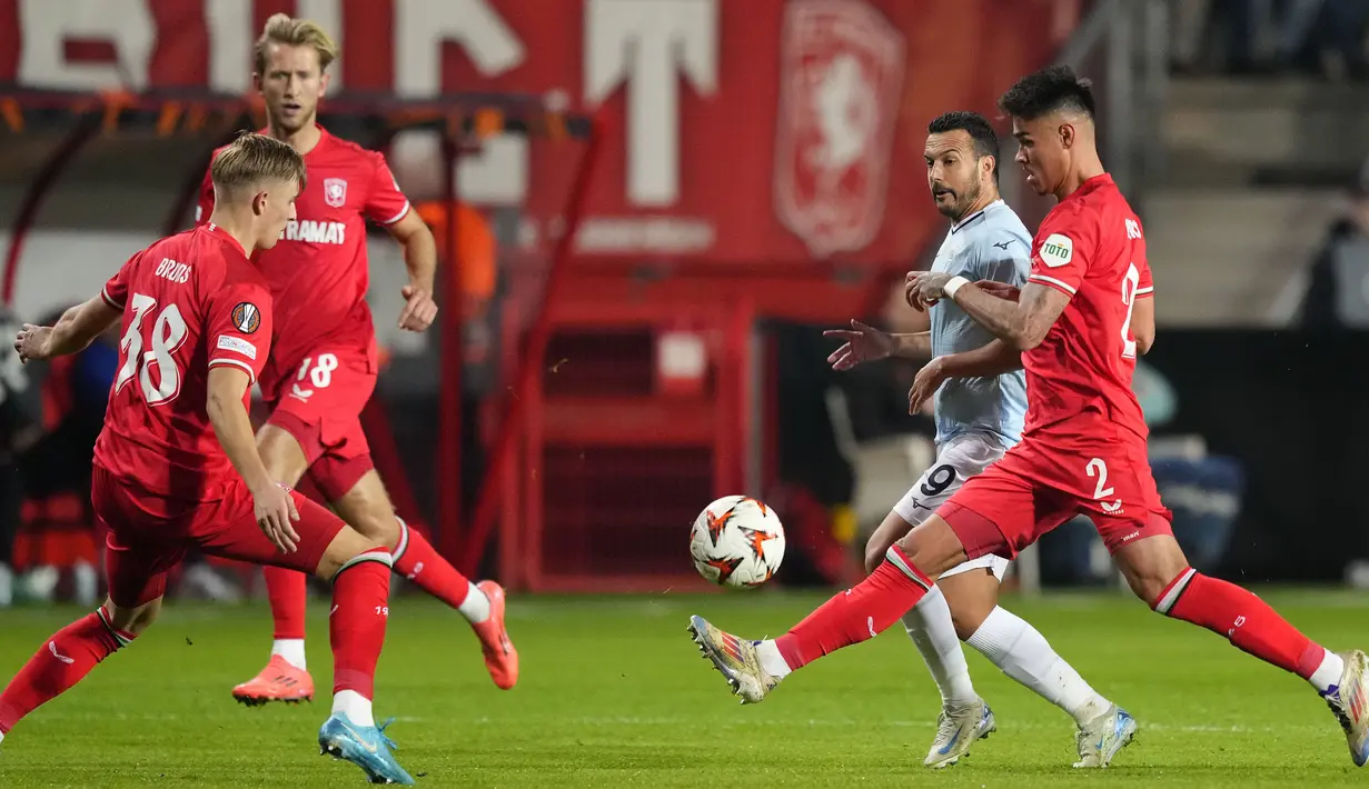 Pemain Twente, Mees Hilgers berusaha menghalau bola saat melawan Lazio dalam laga lanjutan Liga Europa 2024/2025 yang berlangsung di De Grolsch Veste stadium, Enschede, Belanda, Jumat (25/10/2025) dini hari WIB. (AP Photo/Peter Dejong)