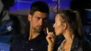 Petenis Serbia, Novak Djokovic berbincang dengan istrinya Jelena selama pertandingan final turnamen amal Tour Adria, antara Dominic Thiem Austria dan Filip Krajinovic Serbia, di Belgrade, Serbia (14/6/2020). Djokovic  dinyatakan positif mengidap Covid-19. (AP Photo/Darko Vojinovic)
