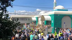 Orang-orang membentuk rantai manusia untuk melindungi jemaah salat Jumat di Hagley Park luar masjid Al-Noor, di Christchurch, Selandia Baru, Jumat (22/3). Ibadah itu digelar sepekan selepas penembakan brutal di kota Christchurch. (Sue Teodoro via REUTERS)