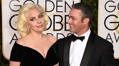 Lady Gaga ditemani Taylor Kinney menghadiri acara Golden Globes 2016 di Beverly Hilton Hotel, California, Minggu (10/1). Kompak mengenakan gaun bernuansa hitam, sang Mother Monster menggandeng mesra sang tunangan. (Jason Merritt/Getty Images/AFP)