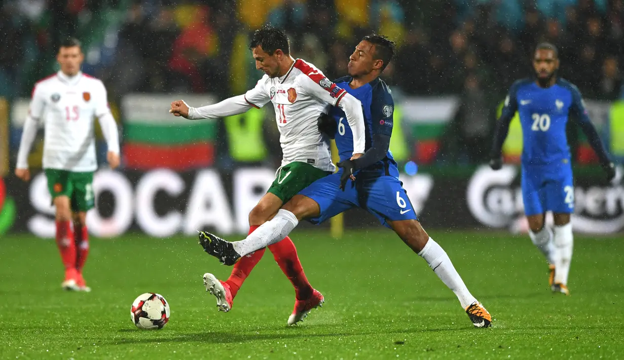 Bek Bulgaria, Stanislav Manolev berebut bola dengan gelandanag timnas Prancis, Corentin Tolisso pada laga Kualifikasi Piala Dunia 2018 zona Eropa Grup A, Sabtu (7/10). Les Bleus unggul 1-0 lewat gol lewat gol Blaise Matuidi. (Dimitar DILKOFF / AFP)