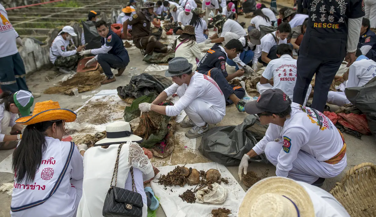 Relawan saat menggali makam tanpa identitas di pemakaman Poh Teck Tung, Thailand, Selasa (3/11/2015). Ribuan jasad tak berindentitas ini nantinya akan dipindahkan ke gudang penyimpanan dan dikremasi. (REUTERS/Athit Perawongmetha)