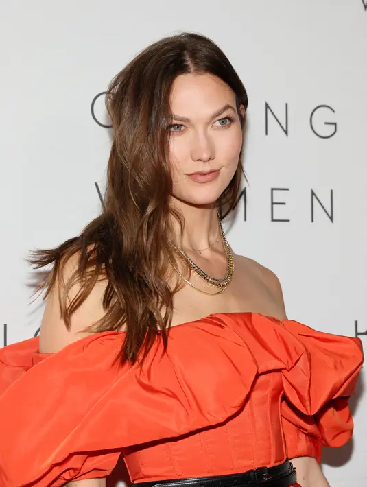 Karlie Kloss berpose saat menghadiri makan malam The Kering Foundation's Caring for Women di The Pool on Park Avenue di New York City pada 15 September 2022. Model 30 tahun itu memasangkan sejumlah rantai emas mengkilap di lehernya.  (Dia Dipasupil/Getty Images/AFP)