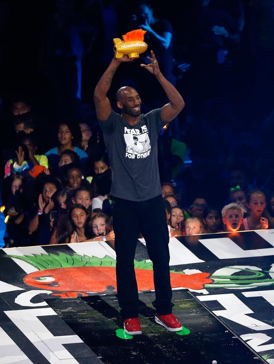 Mantan pemain basket NBA Kobe Bryant mengangkat pialanya saat menerima penghargaan "Legenda" Kids Choice Sport 2016 di Los Angeles, California, (14/7). (REUTERS/Mario Anzuoni)