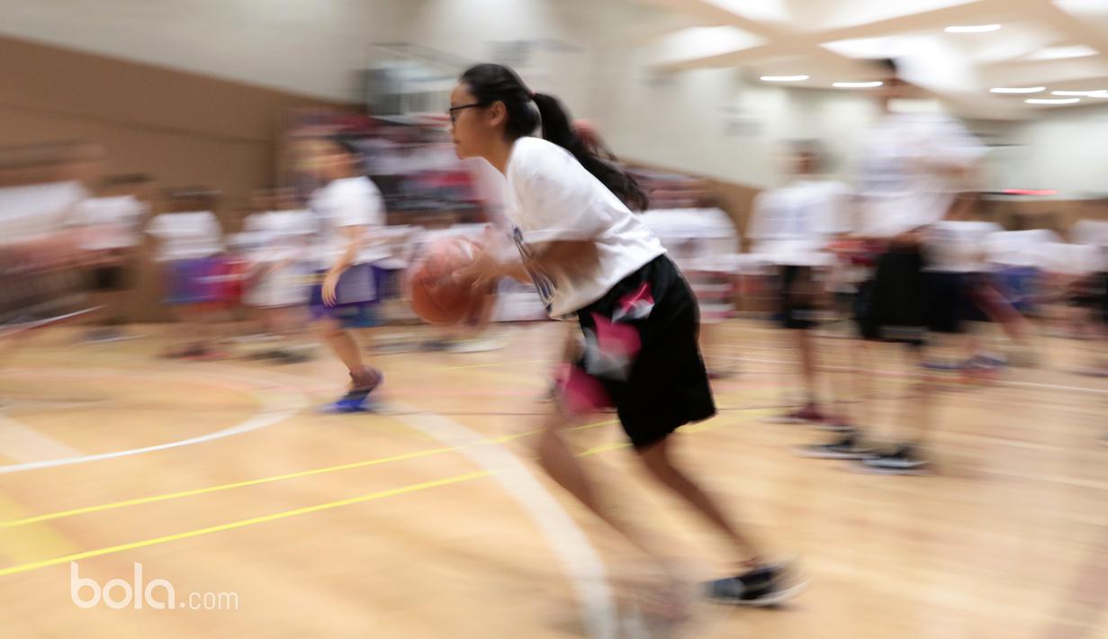 Aksi seorang peserta Basketball Clinic bersama DBL Academy menggiring bola saat berlatih teknik dasar menembak di Thamrin Nine, UOB Plaza, Jakarta, (7/3/2017). (Bola.com/Nicklas Hanotubun)