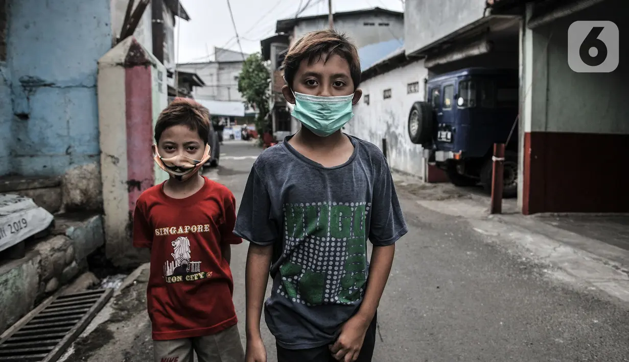 Anak-anak mengenakan masker saat bermain di wilayah Zona Merah RW 03 Kelurahan Kebon Manggis, Jakarta, Selasa (14/7/2020). Terus meningkatnya kasus positif Covid-19 menyebabkan jumlah RW di DKI yang masuk dalam Zona Merah bertambah menjadi 30 lokasi. (merdeka.com/Iqbal Nugroho)
