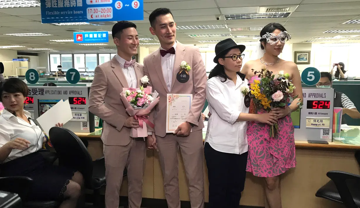 Pasangan sesama jenis Shane Lin dan Marc Yuan serta Cynical Chick dan Li Ying-Chien berpose di kantor pemerintahan Taipei, Taiwan, Jumat (24/5/2019). Diperkirakan ada sekitar 300 pasangan sesama jenis lainnya yang mendaftarkan pernikahan mereka pada hari yang sama. (AP Photo/Johnson Lai)