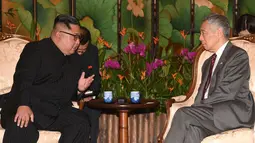 Pemimpin Korea Utara, Kim Jong-un berbincang dengan Perdana Menteri Singapura Lee Hsien Loong di Istana Kepresidenan Singapura, Minggu (10/6). Kim Jong-un dan Donald Trump akan bertemu 12 Juni. (AFP Photo/HO/Kementerian Kominfo Singapura)