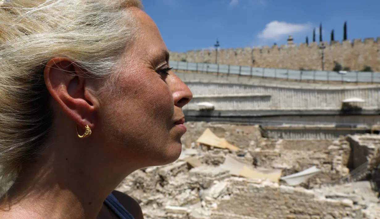 Profesor Cayetana Johnson memakai anting emas langka yang ditemukan di situs arkeologi Kota Daud, Yerusalem Timur, Rabu (8/8). Anting serupa telah ditemukan di seluruh Mediterania, tetapi sangat jarang di Israel. (MENAHEM KAHANA/AFP)