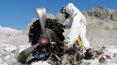 Anggota tentara Swiss mengecek mesin pesawat tempur Perang Dunia II milik AS saat ditemukan di Gauli Glacier, di Bernese Alps, Swiss (17/9). Pesawat Perang Dunia II C-53 Skytrooper Dakota tersebut jatuh tahun 1946. (Peter Klaunzer/Keystone via AP)