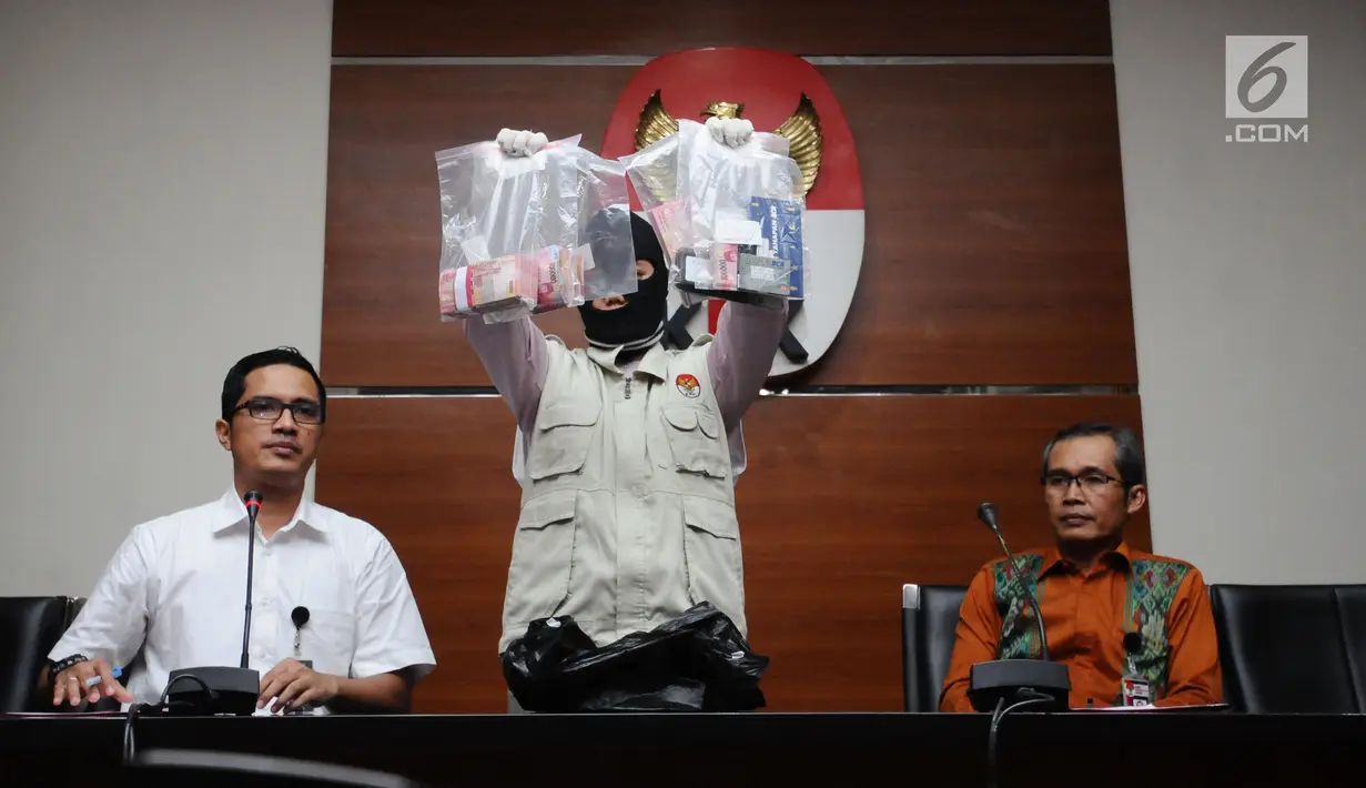 Petugas menunjukkan barang bukti hasil OTT kasus dugaan penyuapan pembahasan perda penyertaan modal Kota Banjarmasin ke PDAM di Gedung KPK, Jakarta, Jumat (15/9). KPK memeriksa empat orang diduga tersangka. (Liputan6.com/Helmi Fithriansyah)