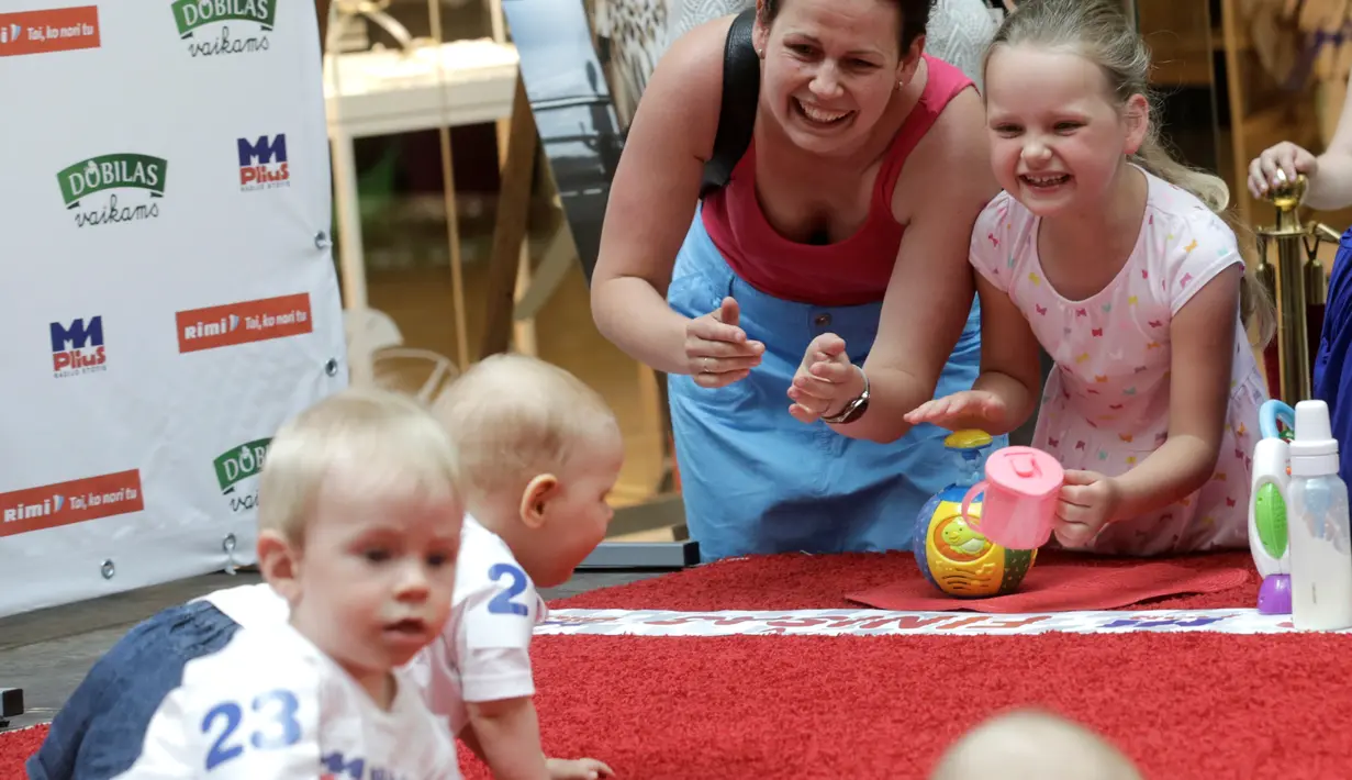 Orang tua memberikan semangat kepada bayinya saat mengikuti lomba 'Balap Bayi' di Vilnius, Lithuania (1/6). Lomba ini diadakan dalam rangka memperingati Hari Anak Internasional. (REUTERS/Ints Kalnins)