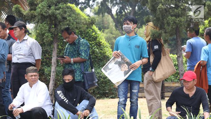 Warga berada di TMP Kalibata untuk melihat prosesi pemakaman Presiden RI ke-3 BJ Habibie, Jakarta, Kamis (12/9/2019). BJ Habibie wafat pada Rabu (11/9) di usia 83 tahun. (Liputan6.com/Helmi Fithriansyah)