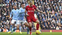 Bek Liverpool, Kostas Tsimikas (kanan) menguasai bola dibayangi gelandang Manchester City, Phil Foden pada laga pekan ke-13 Liga Inggris 2023/2024 di Etihad Stadium, Manchester, Sabtu (25/11/2023). (AP Photo/Rui Vieira)