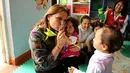 Menteri Kehakiman Peru, Marisol Perez Tello bermain dengan anak-anak  selama kunjungannya di taman kanak-kanak di dalam penjara wanita Santa Monica, Lima, Peru (31/10). (Reuters/Mariana Bazo)