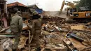 Petugas Satpol PP mengawasi proses pembongkaran rumah warga di Kampung Pulo, Jakarta, Kamis (20/8/2015). 2200 personil gabungan dari Kepolisian dan Satpol PP dikerahkan untuk mengamankan penggusuran tersebut. (Liputan6.com/Helmi Fithriansyah)