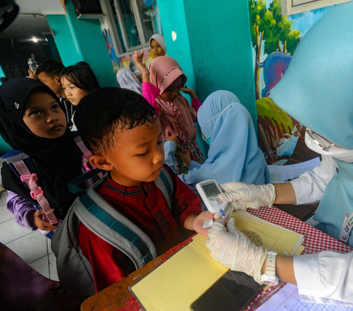 Petugas medis dari Puskesmas Ciputat melakukan tes gula darah pada seorang siswa di SDN 04 Ciputat, Tangerang Selatan, Banten, Jumat (9/8/2024). Puskesmas&nbsp; Ciputat melakukan tes gula darah sebagai bagian dari kegiatan skrining untuk mendeteksi masala