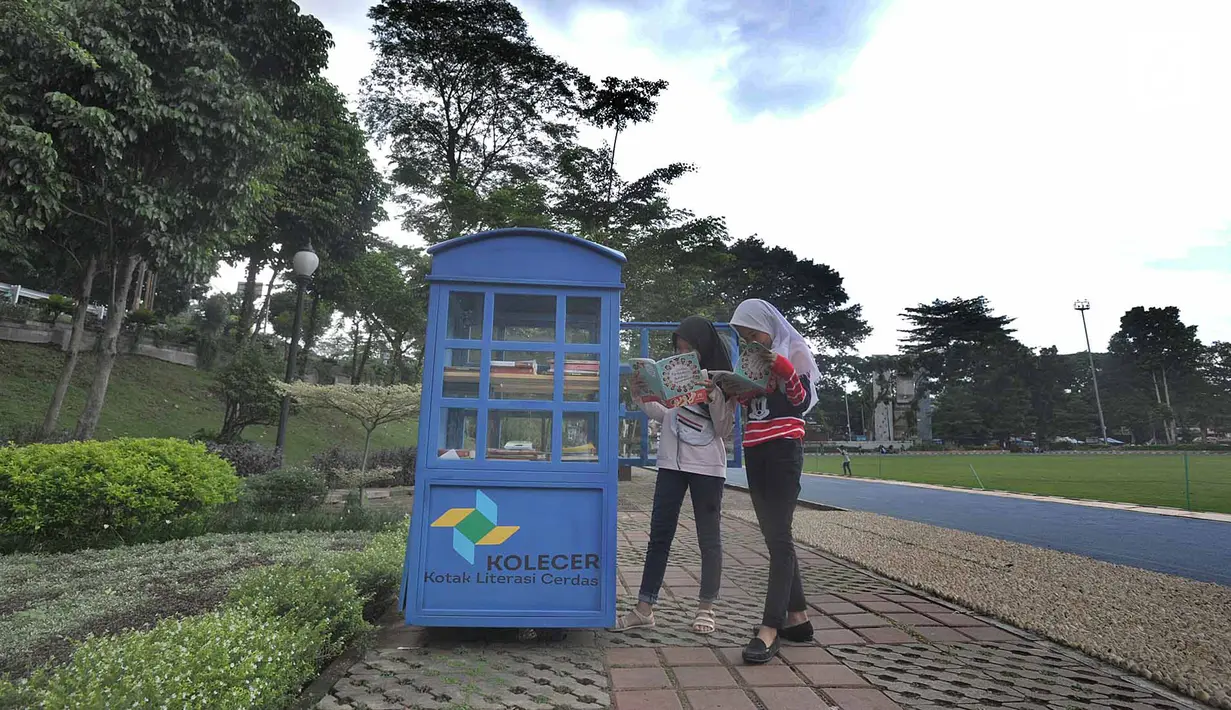Warga membaca buku yang ada di layanan Kotak Literasi Cerdas (Kolecer) di Taman Sempur, Bogor, Jawa Barat, Kamis (20/12). Kehadiran Kolecer bertujuan untuk menumbuhkan budaya literasi. (Merdeka.com/Arie Basuki)